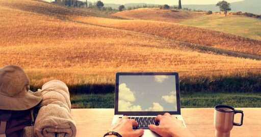 Digital nomad using laptop computer from an hillside italian town